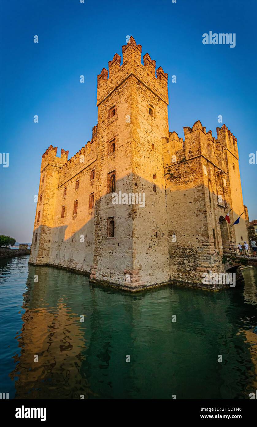 Il Castello Scaligero circondato dal Lago di Garda visto nell'ora d'oro. Foto scattata il 20th agosto 2021 a Sirmione, provincia di Brescia, Lombardia, Ital Foto Stock