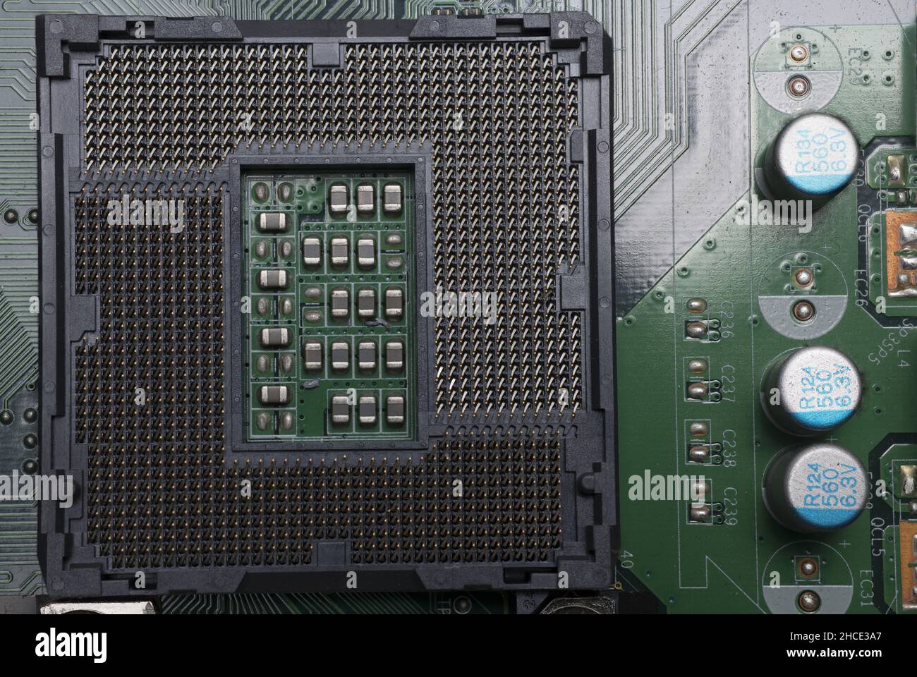 Primo piano di una scheda di computer verde con vari giunti a saldare condensatori transistor e chip su di essa Foto Stock