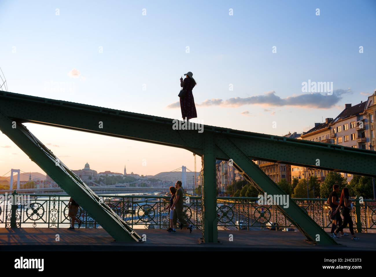 Giovane donna che fotografa in piedi sul fascio del ponte Foto Stock
