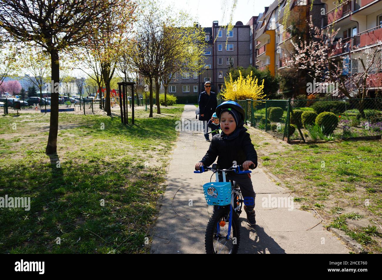 Ragazzo in bicicletta su un sentiero accanto agli appartamenti nel quartiere di stare Zegrze. Foto Stock