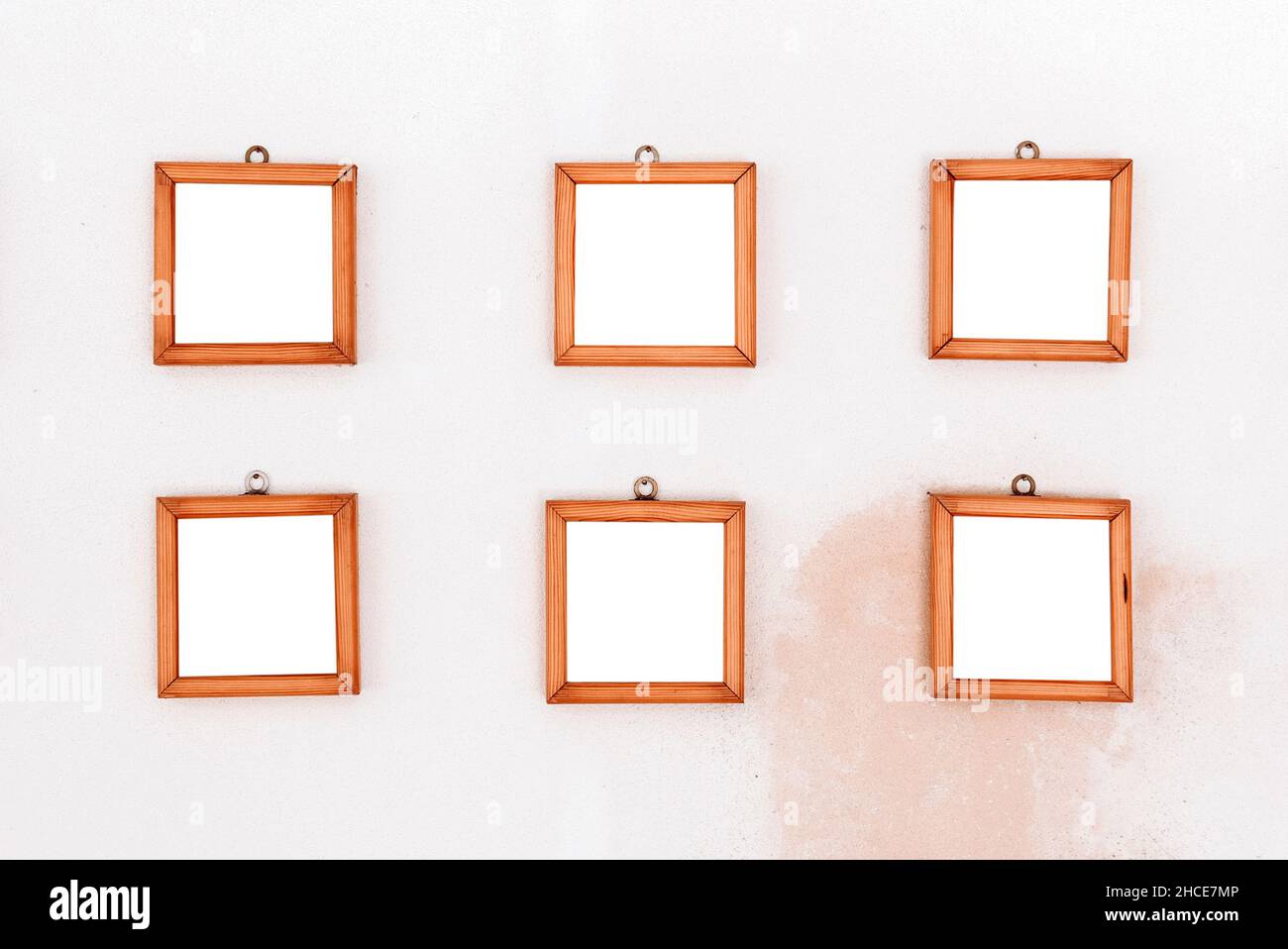 Collezione di sei cornici vuote in legno a forma di quadrato appese a parete Foto Stock