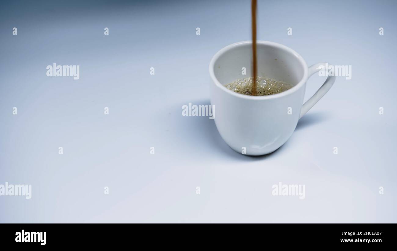 espresso caldo versato in tazza su bianco, immagine stock Foto Stock