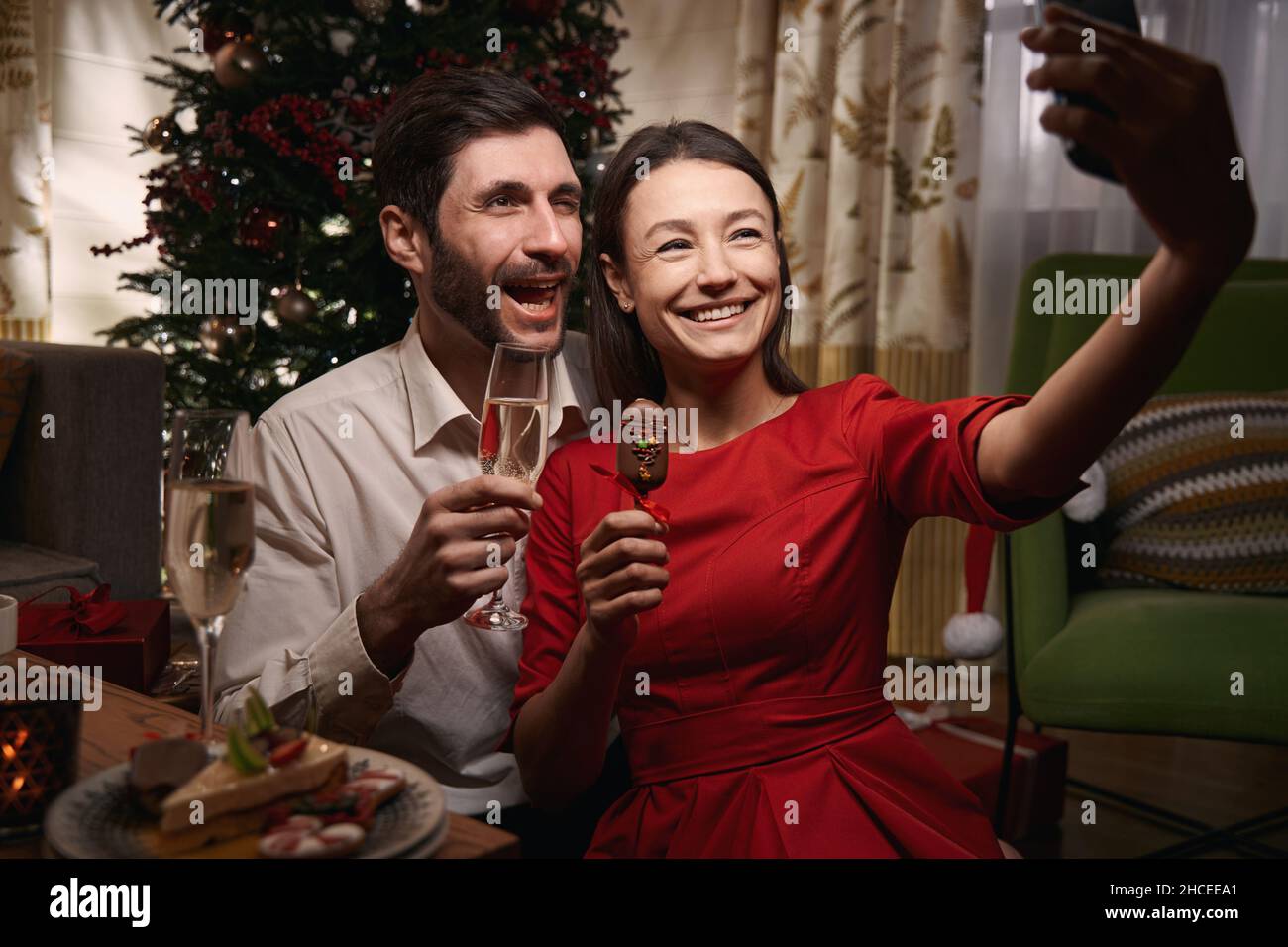 Felice coppia in posa per un selfie la vigilia di natale Foto Stock