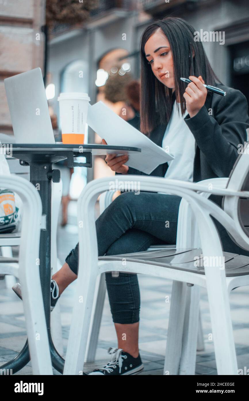 Direttore esecutivo di un'importante azienda che prende appunti e scrive fogli di carta con contratti e rapporti sui suoi dipendenti per il suo lavoro Foto Stock