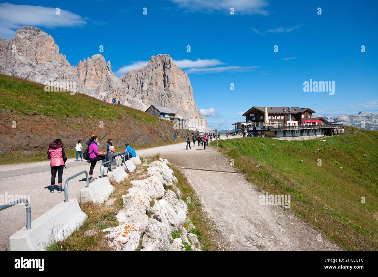 Escursionisti al col Rodella e al rifugio Des Alpes (sullo sfondo del massiccio del Sassolungo), Dolomiti, Val di Fassa, Trento, Trentino-Alto Adige, Italia Foto Stock