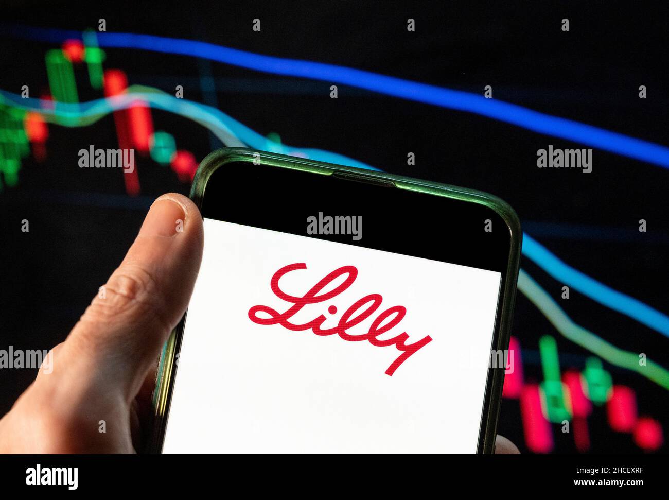 Cina. 4th Dic 2021. In questa illustrazione della foto il logo della società farmaceutica americana Lilly visto su uno smartphone con un grafico di indice di borsa economica sullo sfondo. (Credit Image: © Budrul Chukrut/SOPA Images via ZUMA Press Wire) Foto Stock