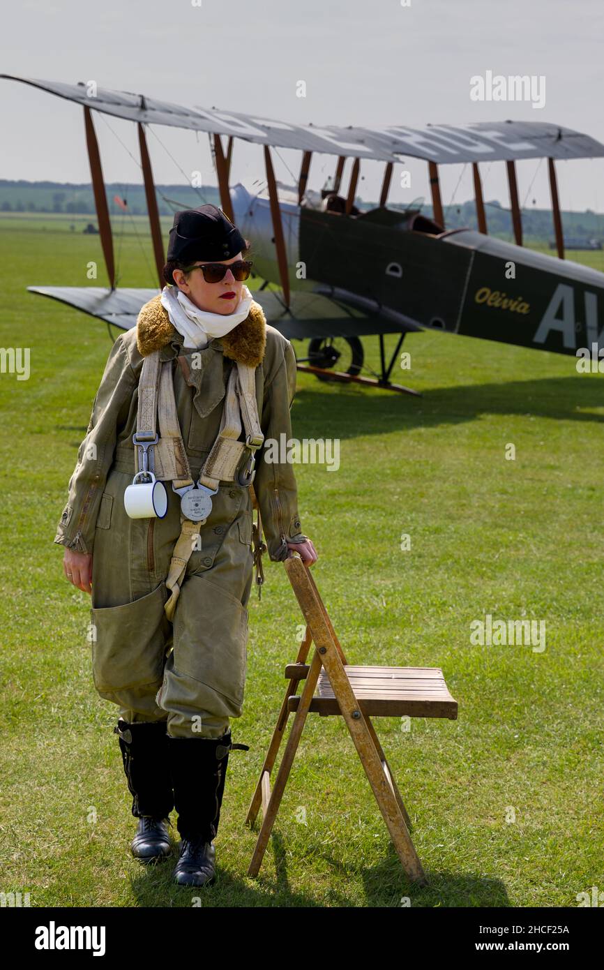 Giovane donna in un abito d'epoca con l'Avro 504K (Replica) Olivia ‘G-EROE’ sullo sfondo al Duxford Air Festival il 27th maggio 2018 Foto Stock