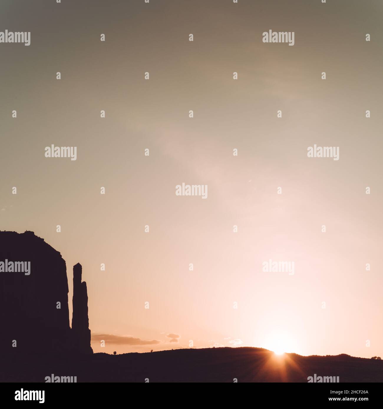 Silhouette di formazioni rocciose nella Monument Valley con il sole che appare Foto Stock