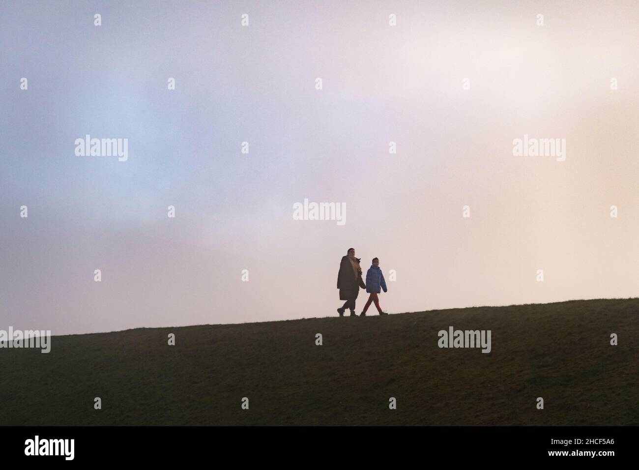Persone che camminano su un verge erboso in una giornata invernale Foto Stock