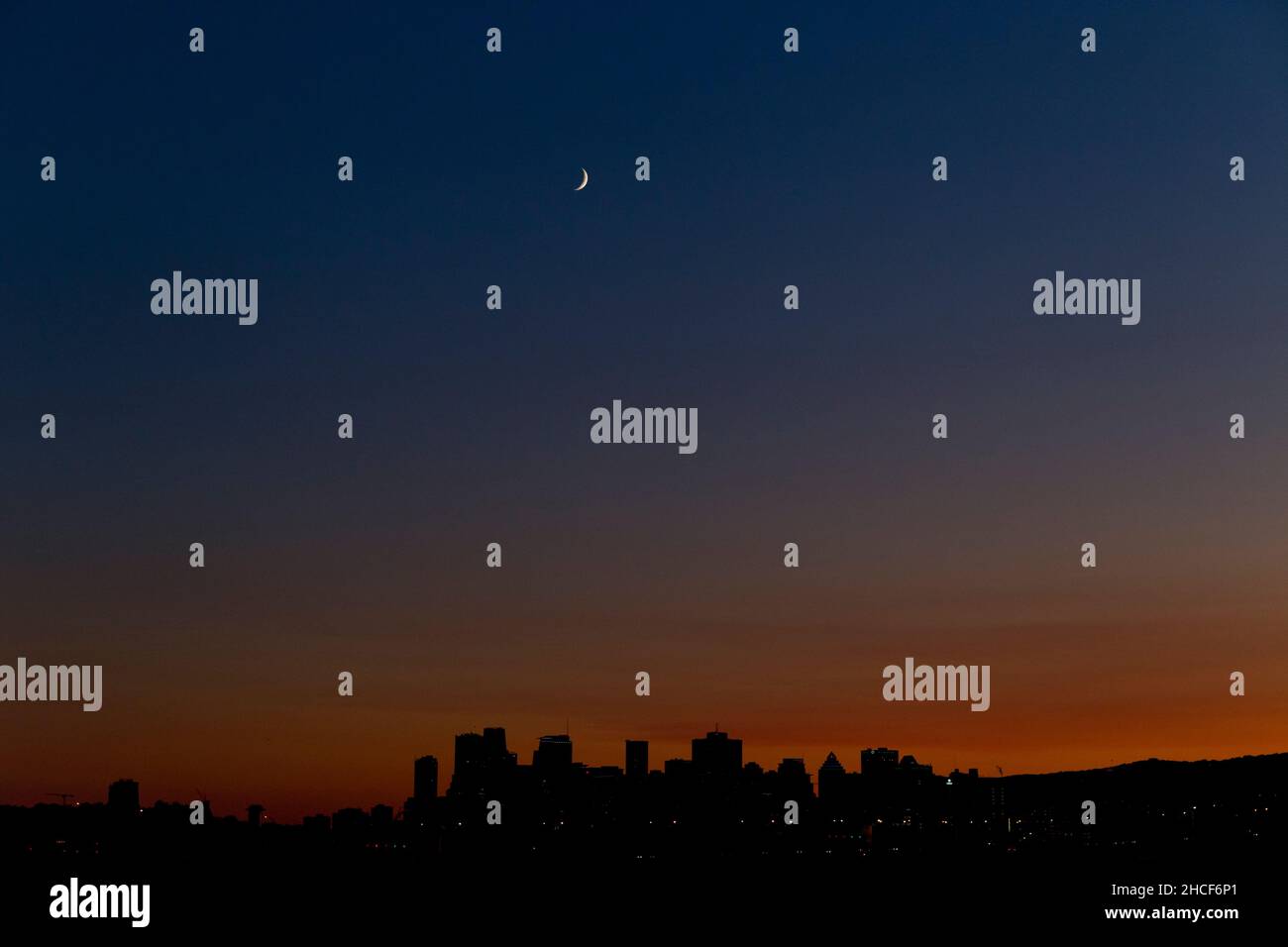 Dopo il tramonto, Quebec, Canada, una luna crescente si aggende sopra lo skyline di Montreal Foto Stock