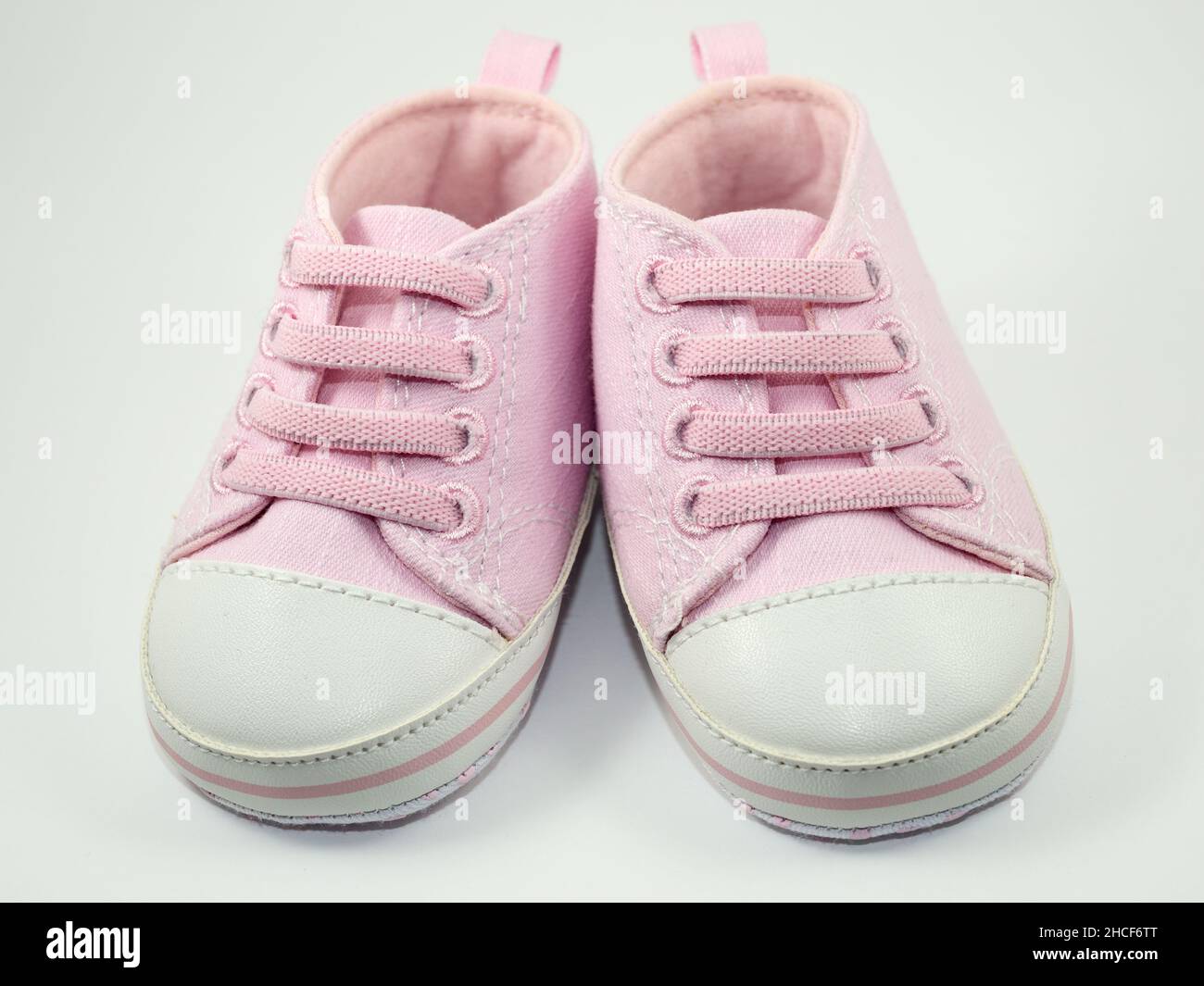 un paio di sneaker rosa di piccole dimensioni su sfondo bianco Foto Stock