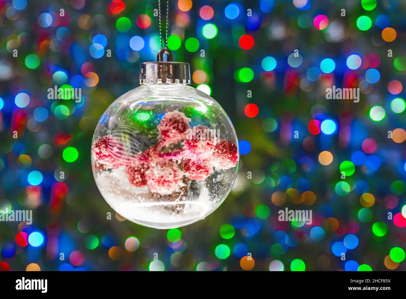 Palla decorativa di Natale su sfondo bokeh sfocato multicolore. Foto Stock