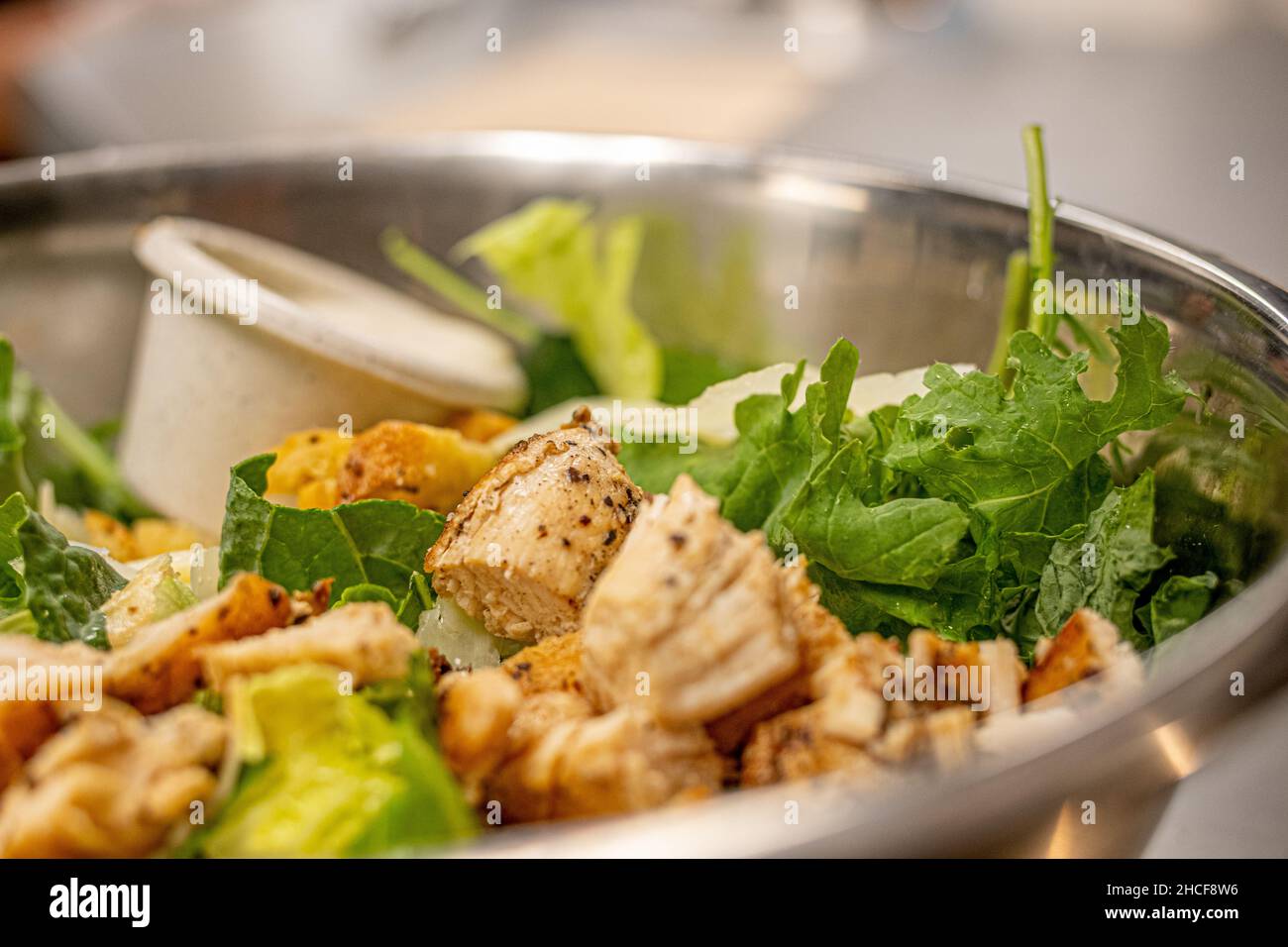 Un primo piano di una deliziosa insalata di pollo con verdure in un contenitore metallico Foto Stock
