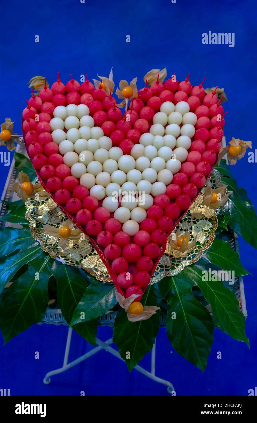 bel cuore fatto con palline di melone e melone e decorato con nisperos (perle) Foto Stock