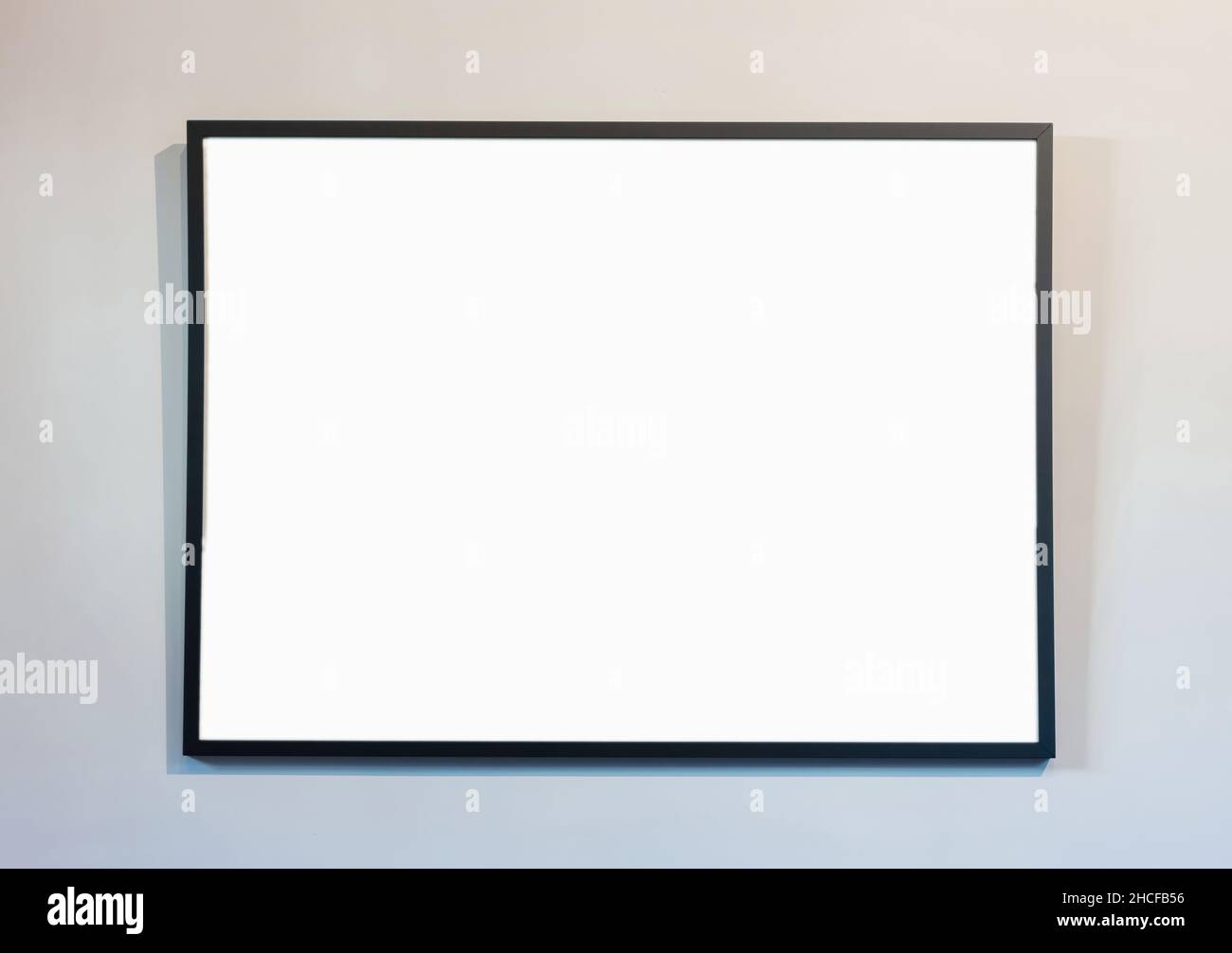 Cornice vuota su sfondo bianco della parete, spazio di copia. Poster mockup. Bordo nero, moderno, minimo per testo, annuncio, presentazione del prodotto Foto Stock