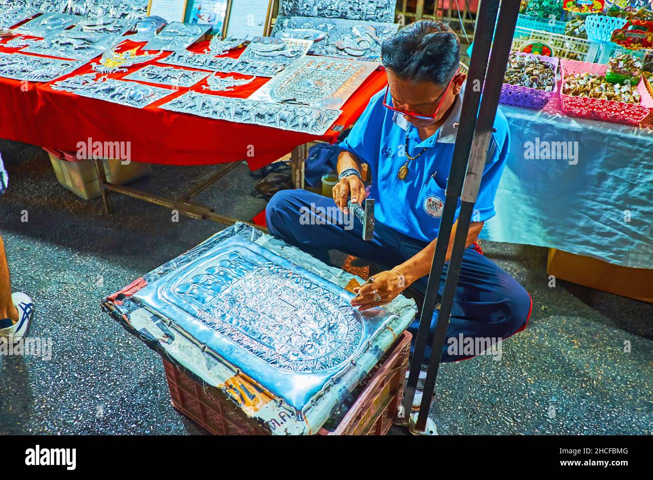 CHIANG mai, THAILANDIA - 4 MAGGIO 2019: L'argentiere crea un'impronta di Buddha ornata sul piatto in un laboratorio all'aperto d'argento, Sabato notte mercato a Wua Foto Stock