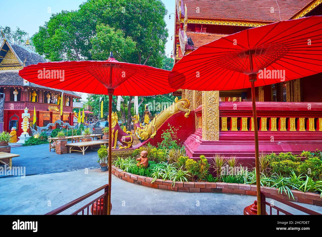 Due tradizionali ombrelloni tailandesi rossi di fronte ai santuari storici del Tempio d'Argento, Chiang mai, Thailandia Foto Stock