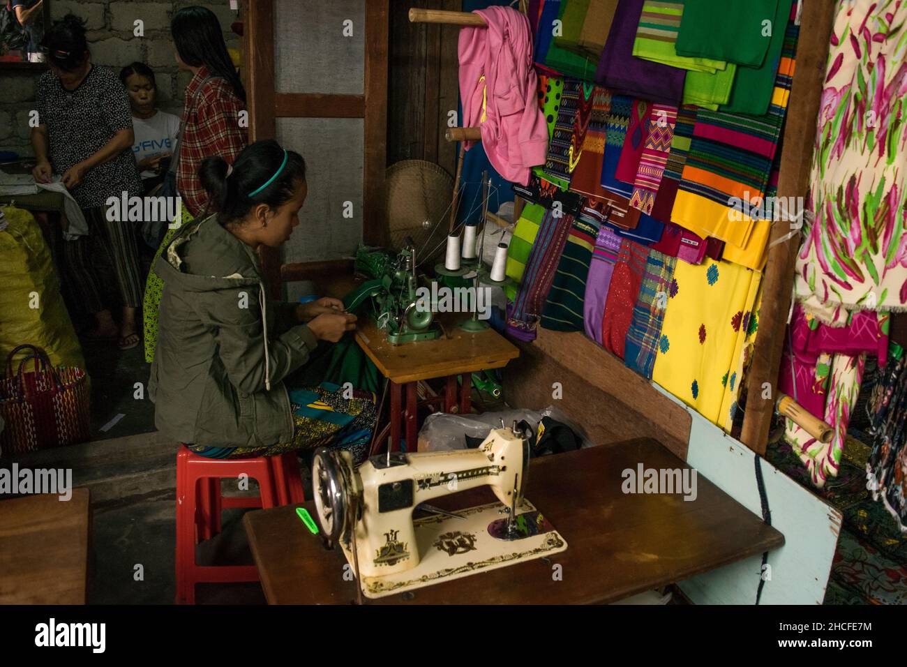 Venditore di tessuti e tessuti, che vende prodotti dai colori brillanti al mercato Nyaung Shwe, vicino al lago Inle Foto Stock