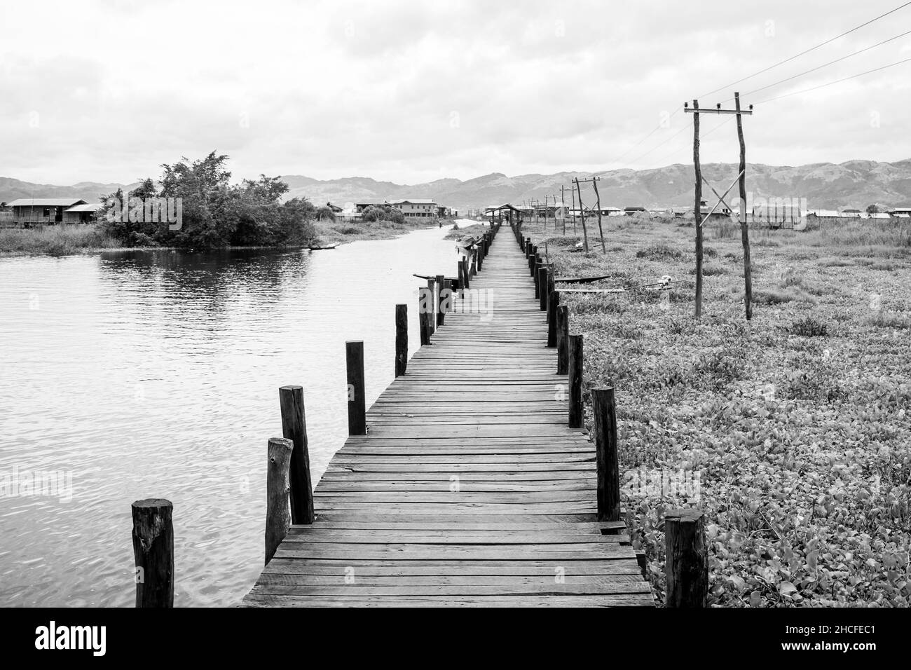 Un ponte di legno usato per camminare lungo le città del lago di Inle, la regione di Shan, Myanmar, mentre il livello dell'acqua aumenta Foto Stock