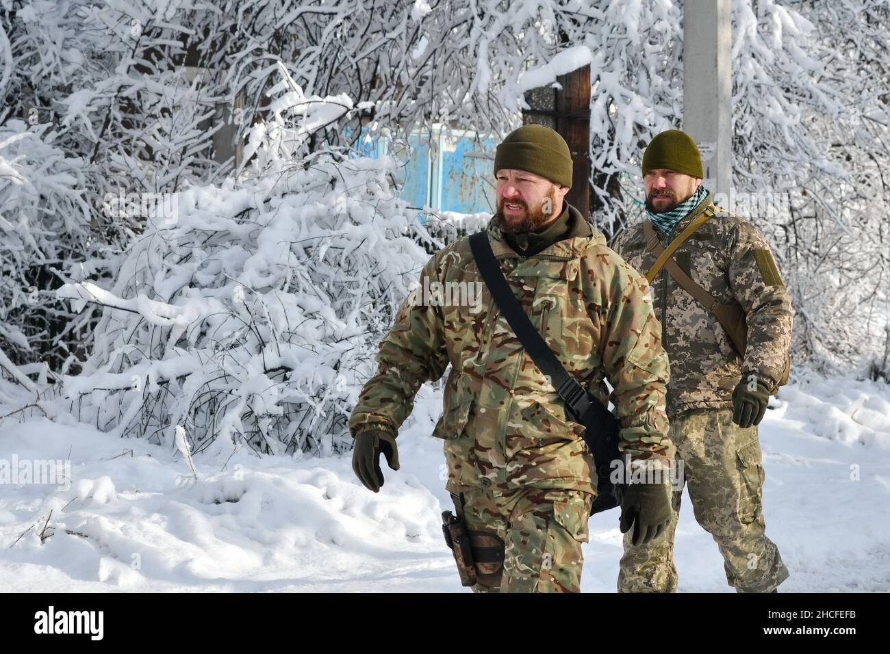 Verkhnotoretske, Ucraina. 27th Dic 2021. I soldati ucraini dell'esercito sono visti camminare per la strada del villaggio di Verkhnotoretske che si trova sulla linea di confine tra l'Ucraina e DPR posizioni.diplomatici russi parteciperanno a colloqui con gli Stati Uniti nel gennaio 2022 su una lista di garanzie di sicurezza che Mosca vuole da Washington in mezzo simmering Tensione tra la coppia sopra l'Ucraina. Il vice ministro russo della difesa nel dicembre 2021 ha avvertito gli ambasciatori stranieri di un "alto rischio” di conflitto tra il paese e la vicina Ucraina. Credit: SOPA Images Limited/Alamy Live News Foto Stock