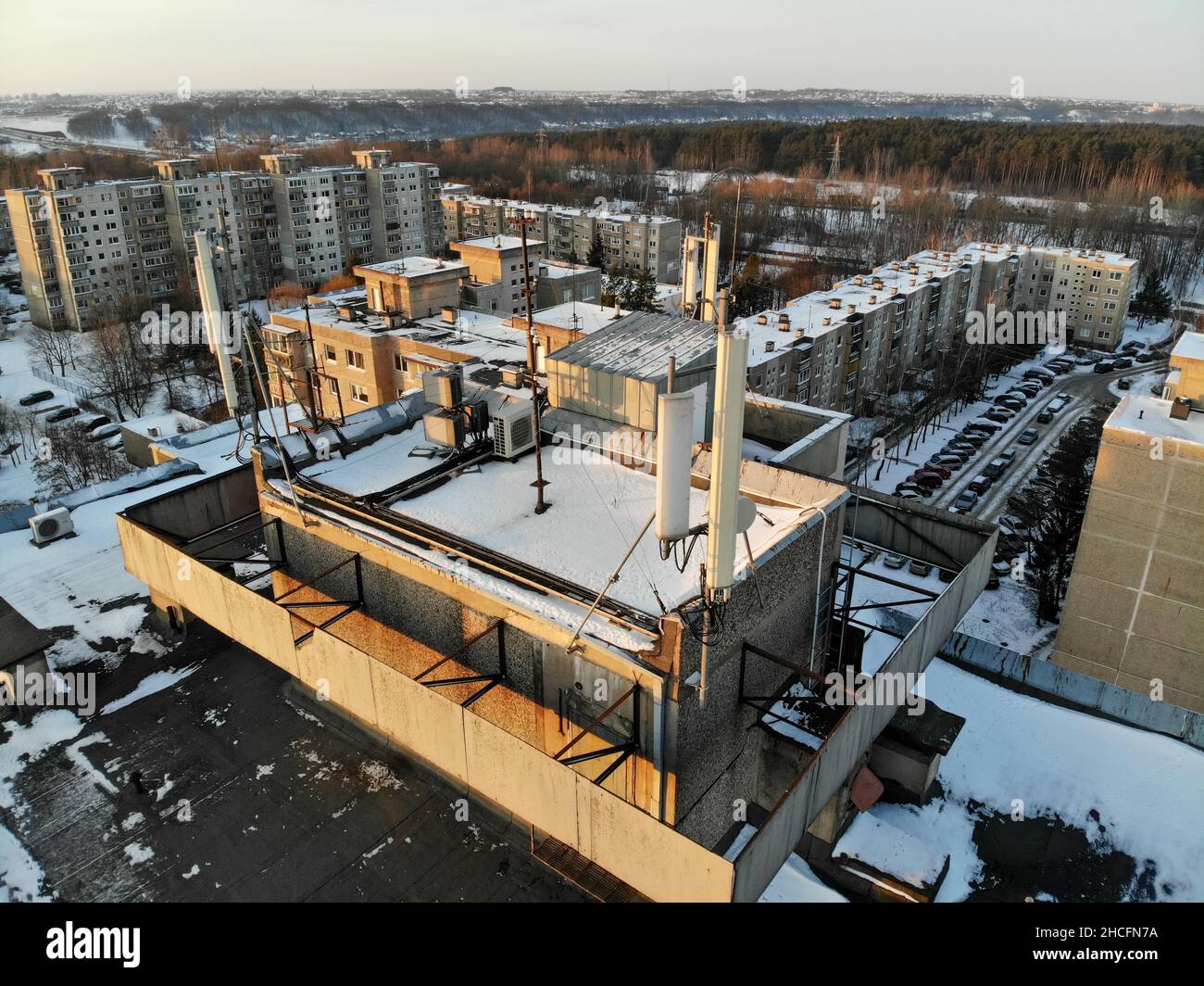 Vista aerea delle antenne GSM e delle telecomunicazioni sul tetto dell'edificio urbano a più piani Foto Stock