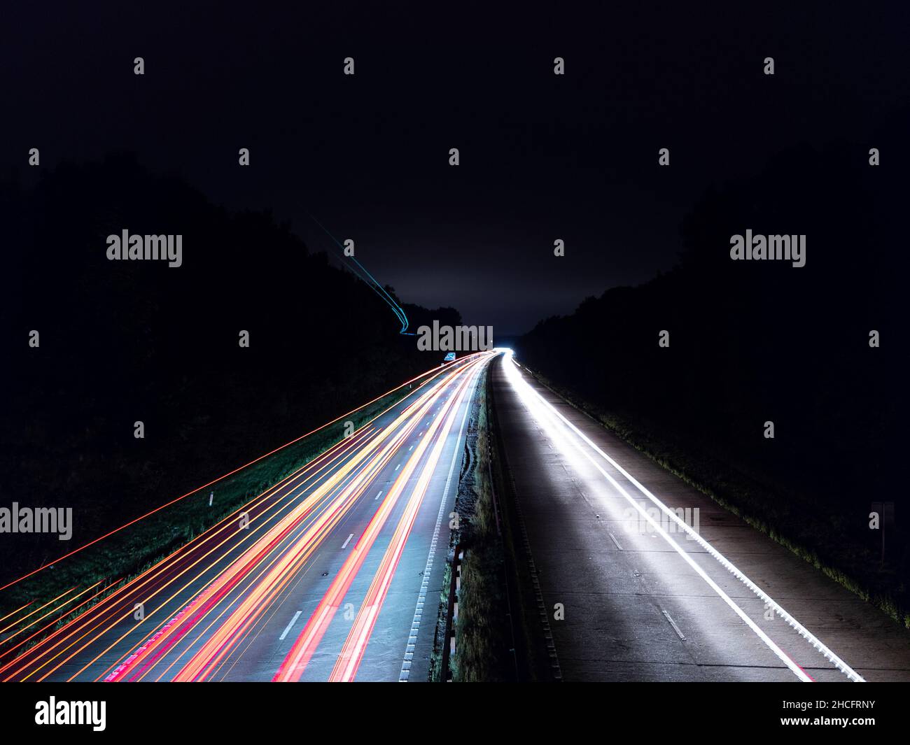 Lunga esposizione del traffico notturno di un'autostrada con sentieri luminosi colorati Foto Stock