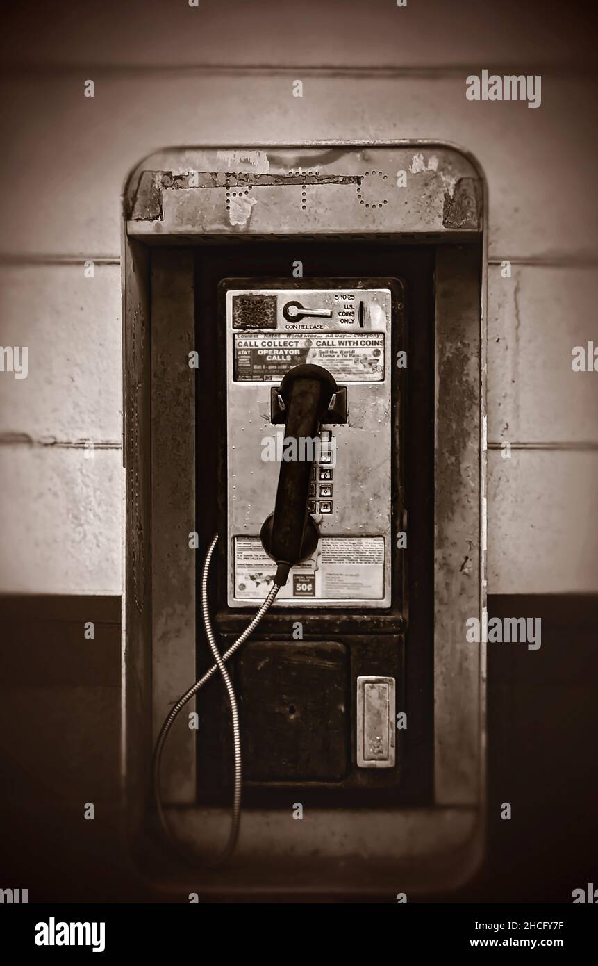 Un telefono pubblico a gettoni chiamato anche un telefono a pagamento, appende sul muro al di fuori di Coden Grocery, 27 dicembre 2021, a Coden, Alabama. Foto Stock
