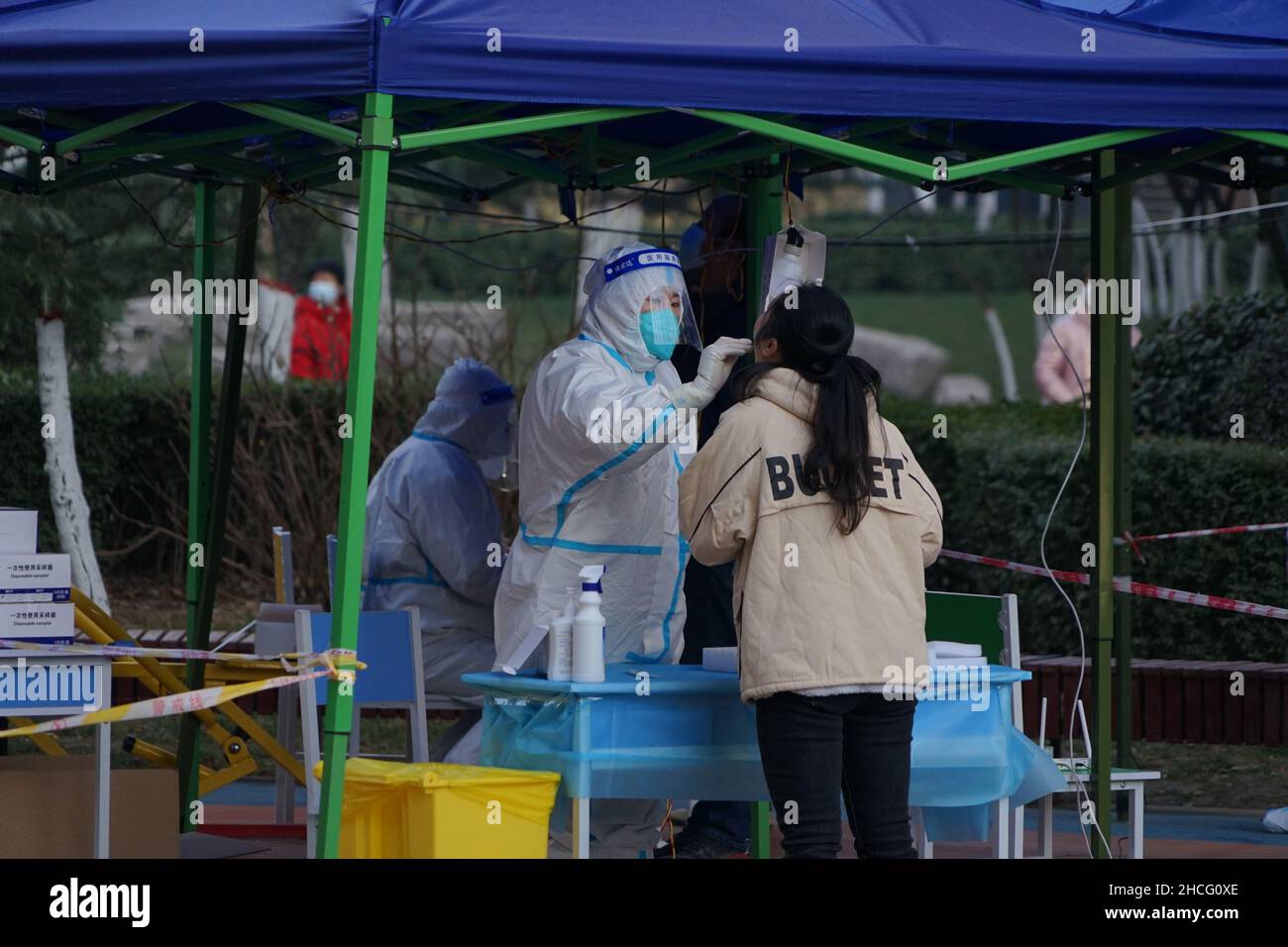 XI'AN, CINA - 29 DICEMBRE 2021 - Un membro dello staff dà ai residenti un test dell'acido nucleico ogni due giorni in una comunità chiusa a Xi'an, provincia di Shaanxi Foto Stock