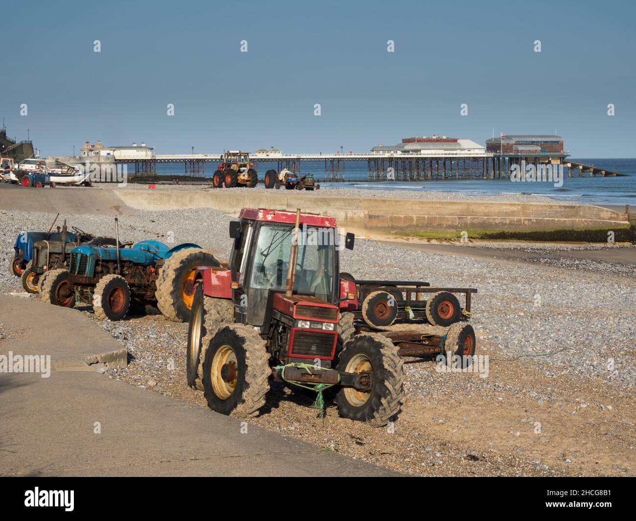 Trattori di pescatori sulla spiaggia a Cromer soleggiato, Norfolk, Inghilterra Foto Stock