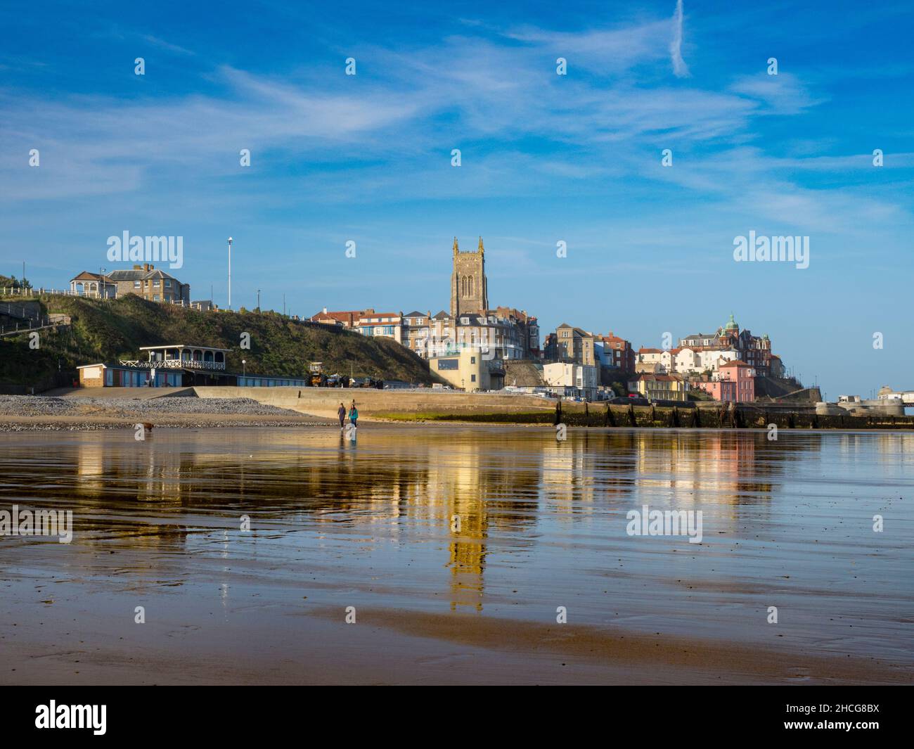 Vista del Cromer cittadina con la riflessione sulla sabbia bagnata. Foto Stock