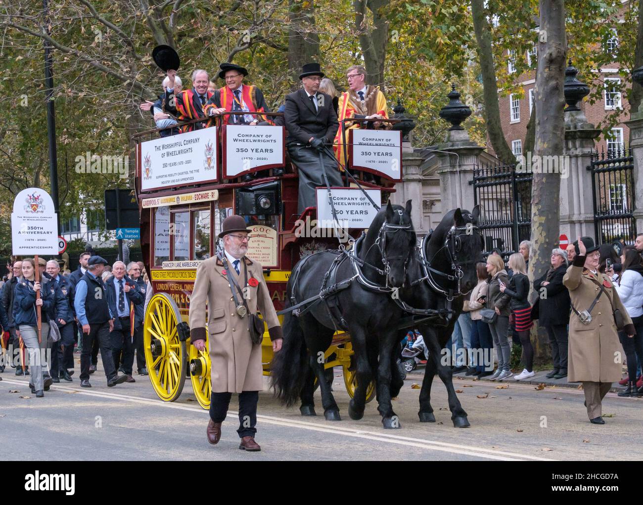 Membri della Wheelwrights' Company, in tradizionali camici di livrea che cavalcano su un omnibus di 1911 cavalli durante il Lord Mayor’s Show 2021, Londra. Foto Stock