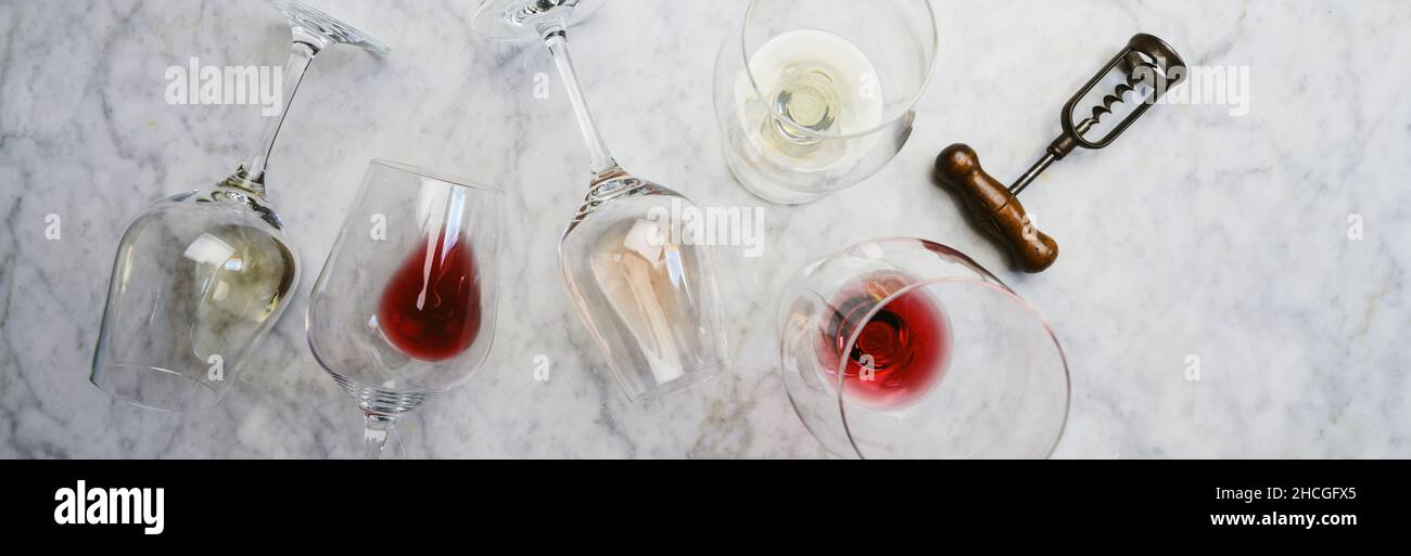 Piatto di vino rosso, rosa e bianco in calici e cavatappi su sfondo di marmo bianco, vista dall'alto, composizione orizzontale. Enoteca, cantina, vino Foto Stock