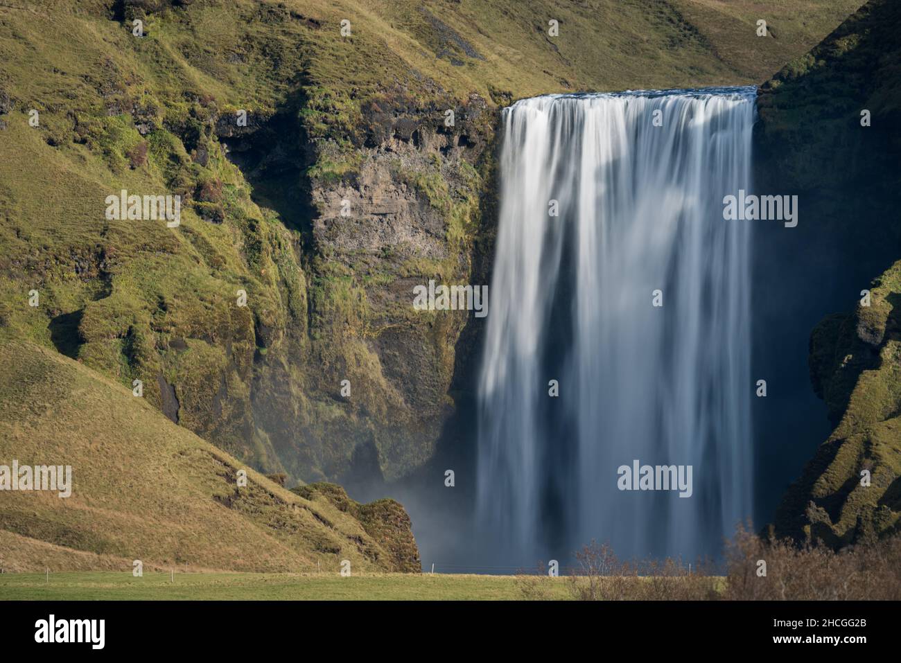 Lunga esposizione della famosa cascata di Skogafoss in lontananza Foto Stock