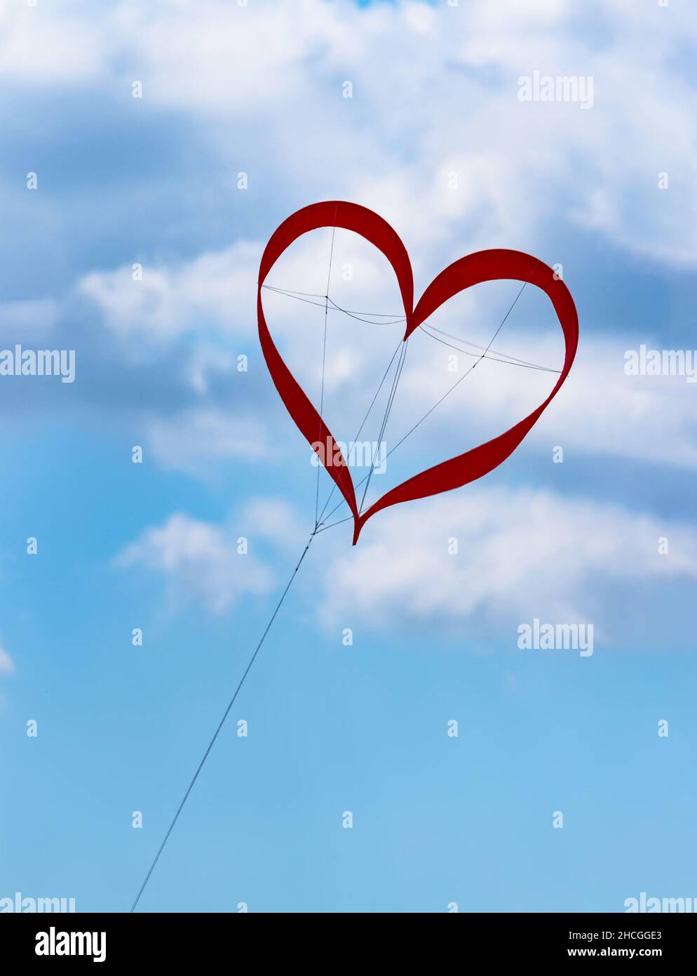 Aquilone rosso a forma di cuore nel cielo blu con nuvole al festival degli aquiloni simboleggia la felicità amore nel matrimonio di una vita felice Foto Stock