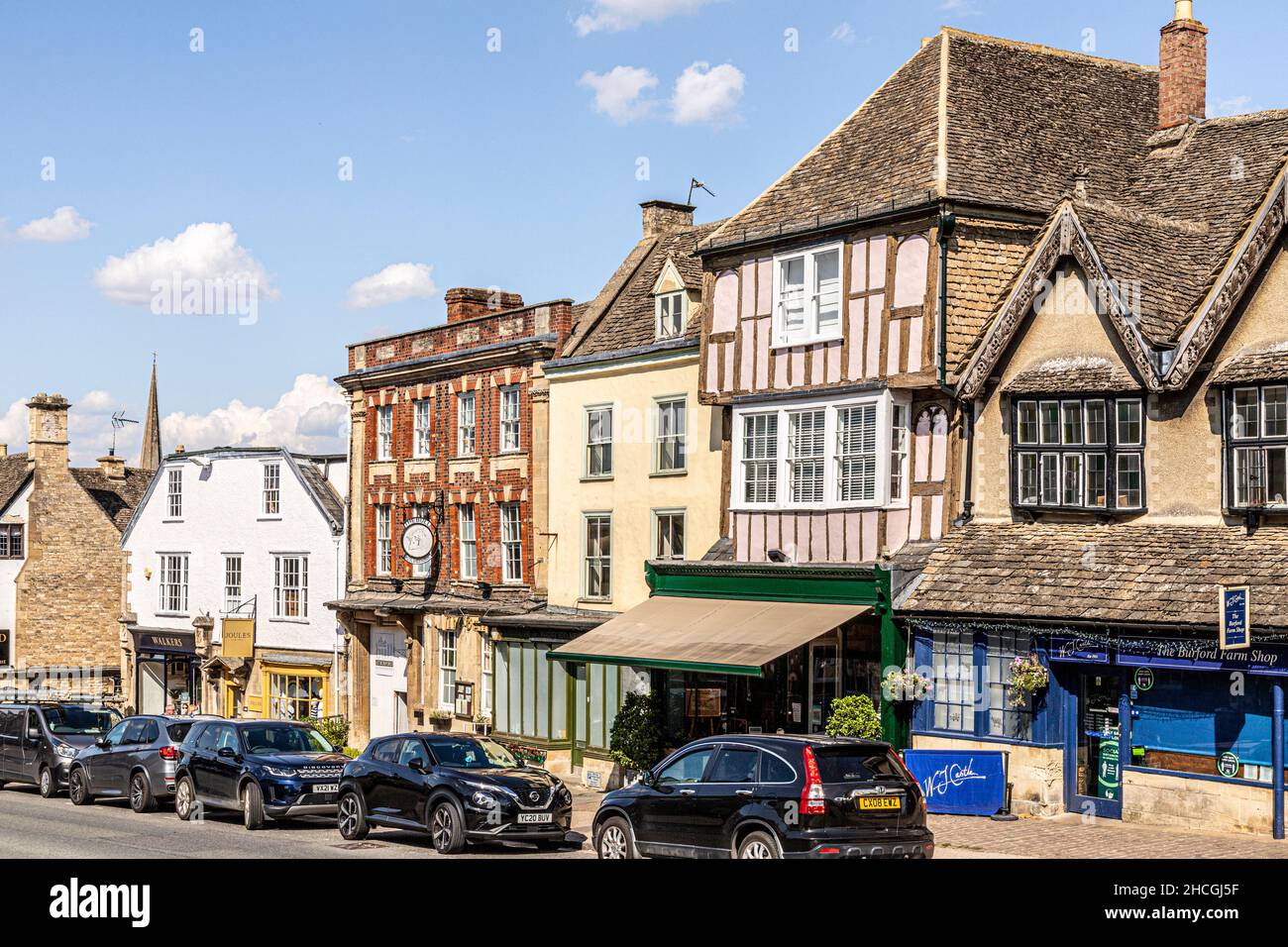 Edifici di diversi periodi e stili architettonici nella High Street della città Cotswold di Burford, Oxfordshire Regno Unito Foto Stock