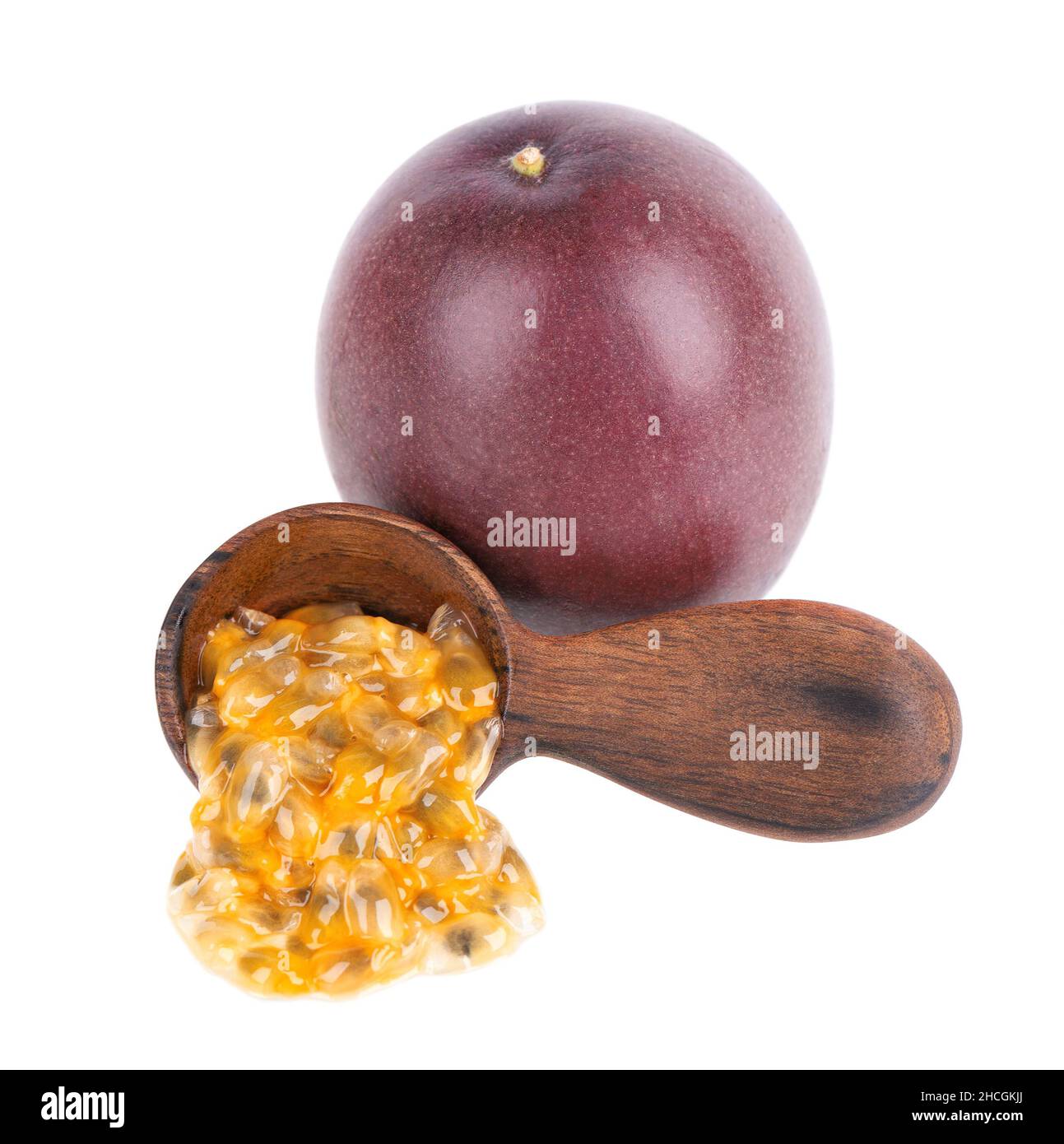 Semi di frutto della passione in cucchiaio di legno, isolato su sfondo bianco. Polpa di passionfrutto o maracuya, frutta esotica. Foto Stock