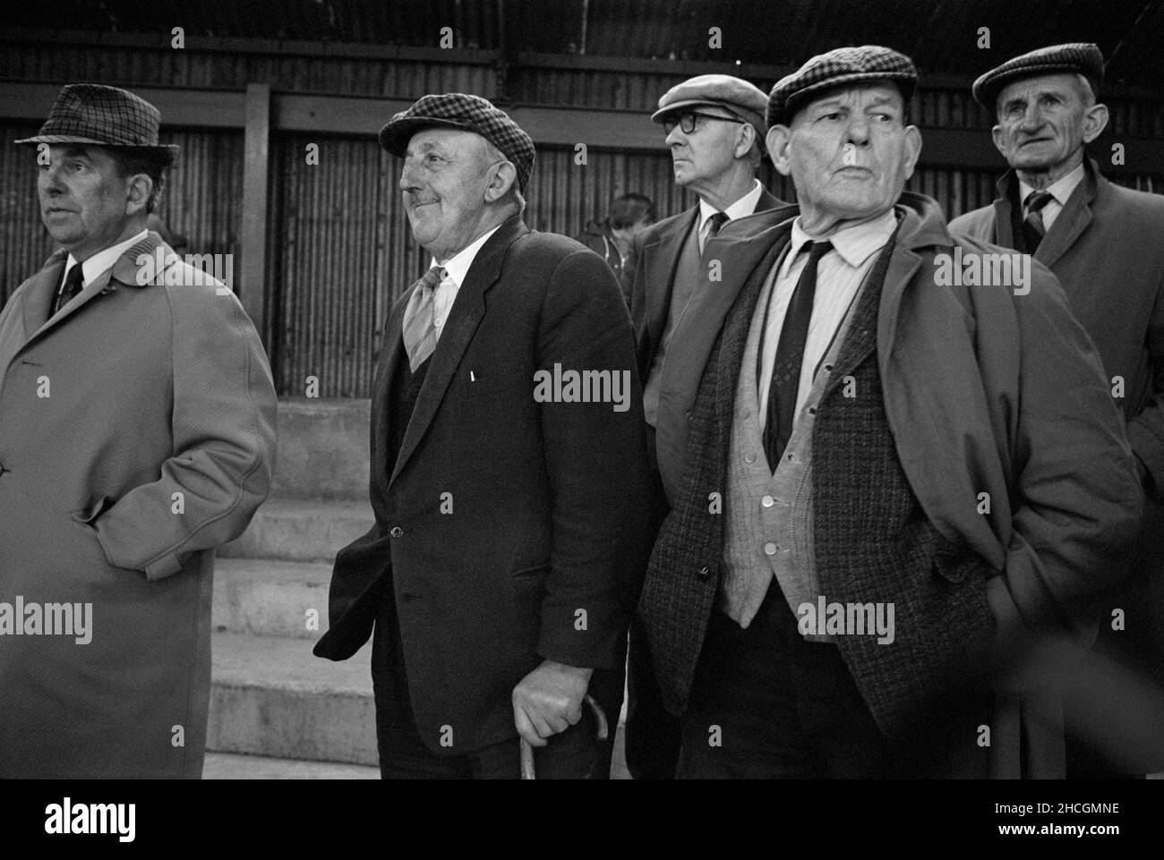 Agricoltori che guardano l'asta al mercato del bestiame di Abergavenny, Galles del Sud, 1976 Foto Stock