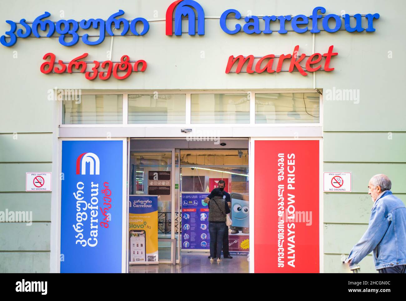 Il ragazzo addetto alla sicurezza del negozio controlla la temperatira del cliente all'interno presso l'ingresso al supermercato carrefour. 8th ottobre, 2020.Tbilisi.Georgia Foto Stock