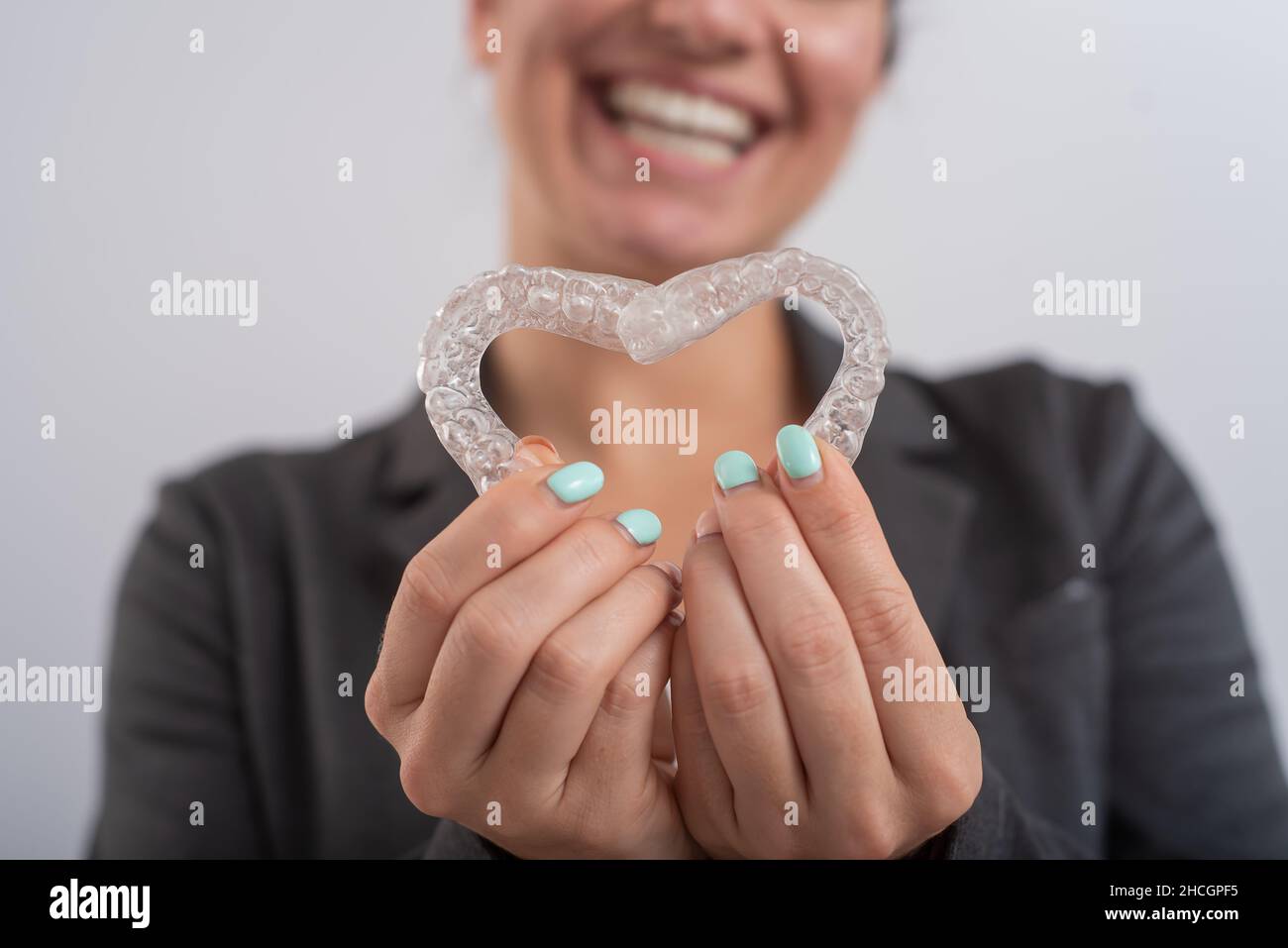 Donna caucasica con due allineatori trasparenti a forma di cuore Foto Stock