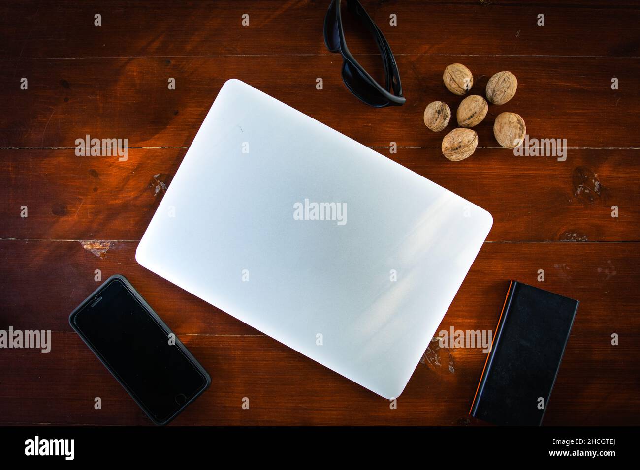 Molti gadget portatili sul tavolo di legno rosso. Configurazione di ricarica durante i viaggi leggeri. Energia per oggetti elettronici portatili personali. Foto Stock