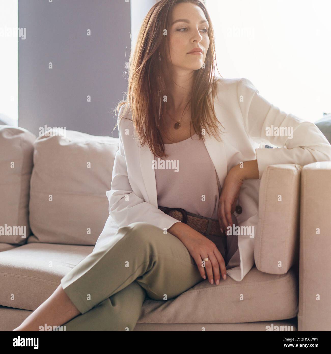 Ritratto di giovane donna in abbigliamento casual business seduto sul divano Foto Stock