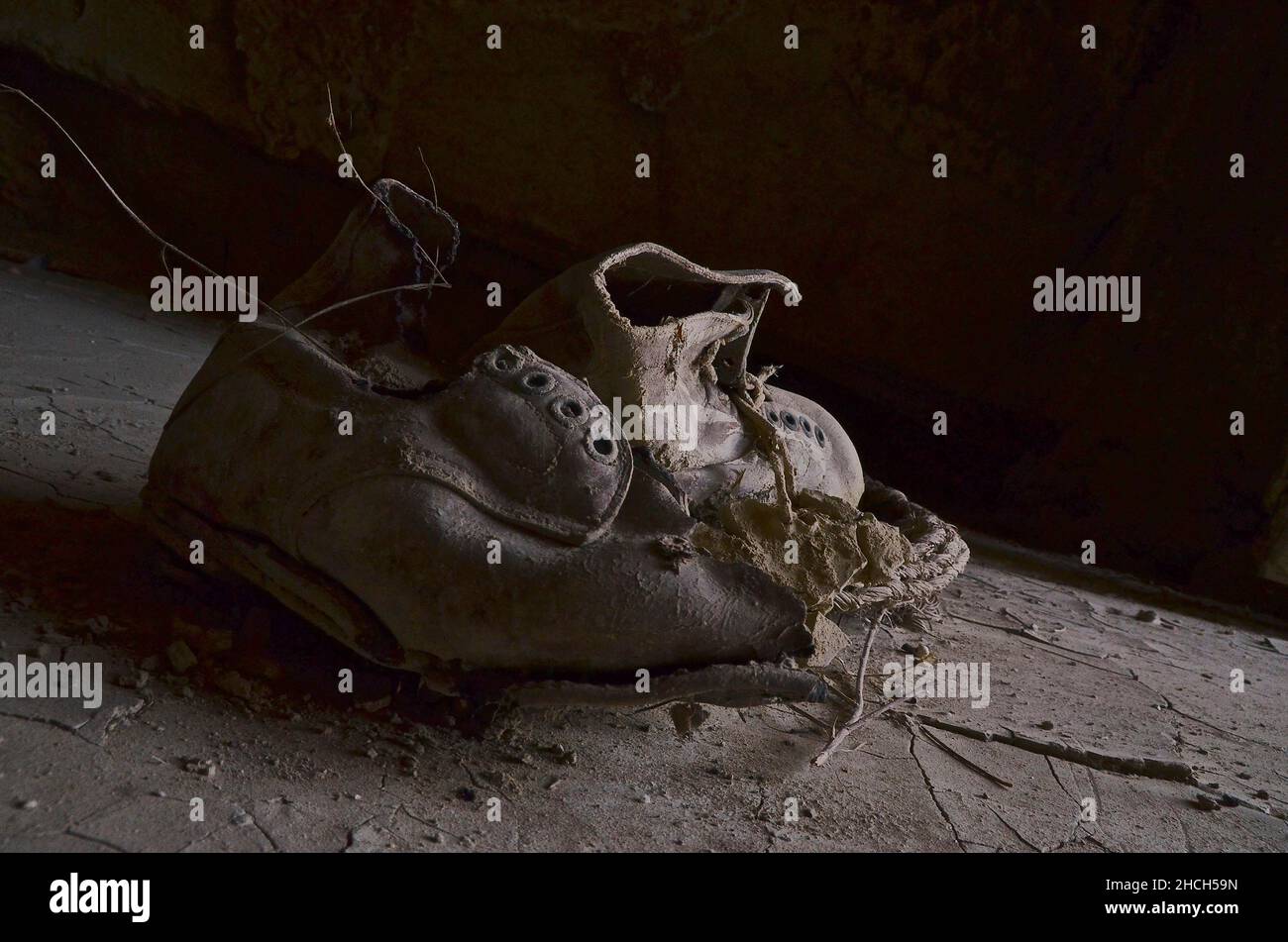 Due scarpe da lavoro su terreno argilloso Foto Stock