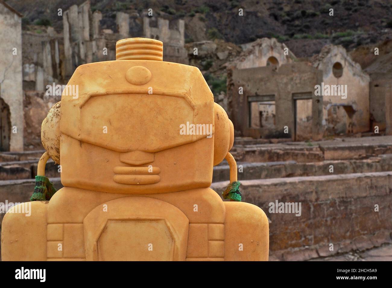 Testa di una figura plastica gialla di fronte alle rovine di una miniera a Mazarron, Murcia, Spagna Foto Stock