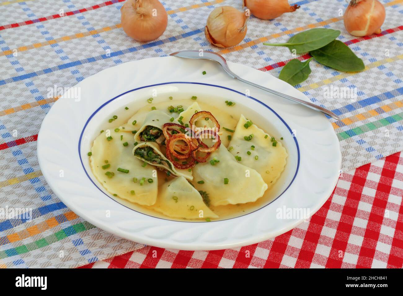 Cucina sveva, Maultaschen in brodo con anelli di cipolla stufati e erba cipollina, piatto per zuppa, cucchiaio, Germania Foto Stock