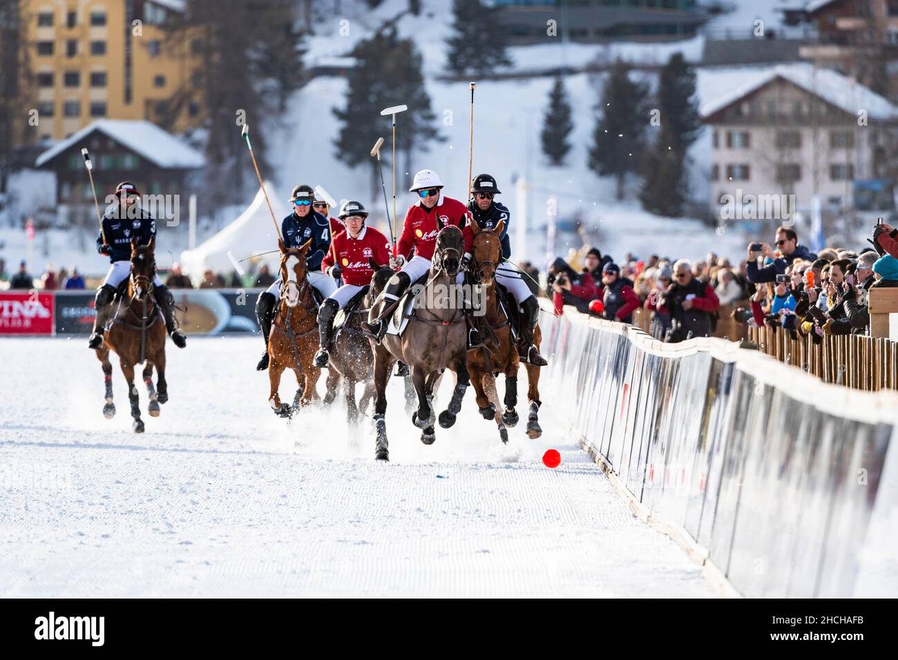 I giocatori del Team Maserati (blu) e del Team St. Moritz (rosso) lottano per la palla con il pieno sforzo fisico sulla ferrovia, 36th Snow Polo Foto Stock