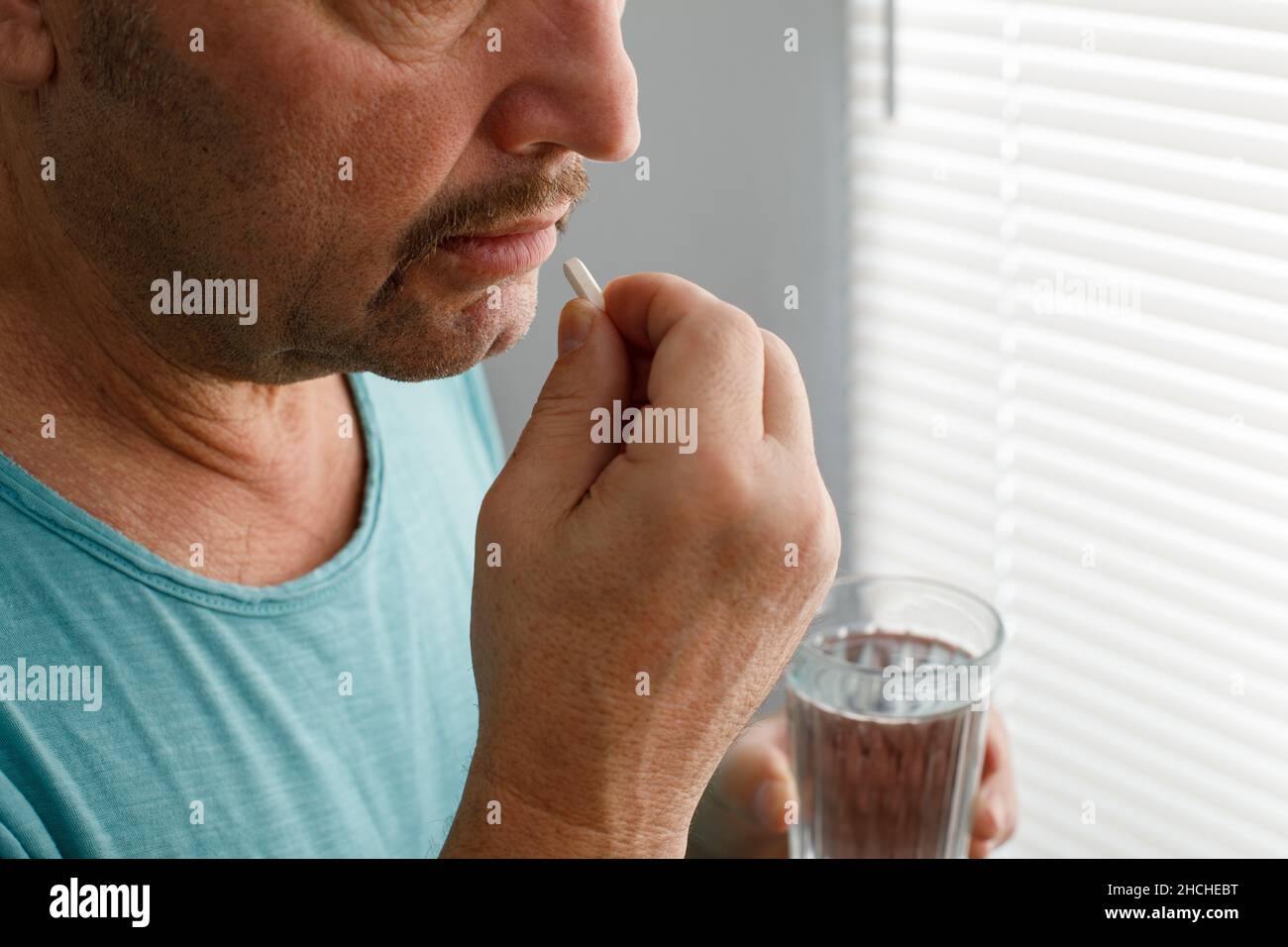 Un uomo che soffre di un hangover prende la medicina per un hangover. Foto Stock