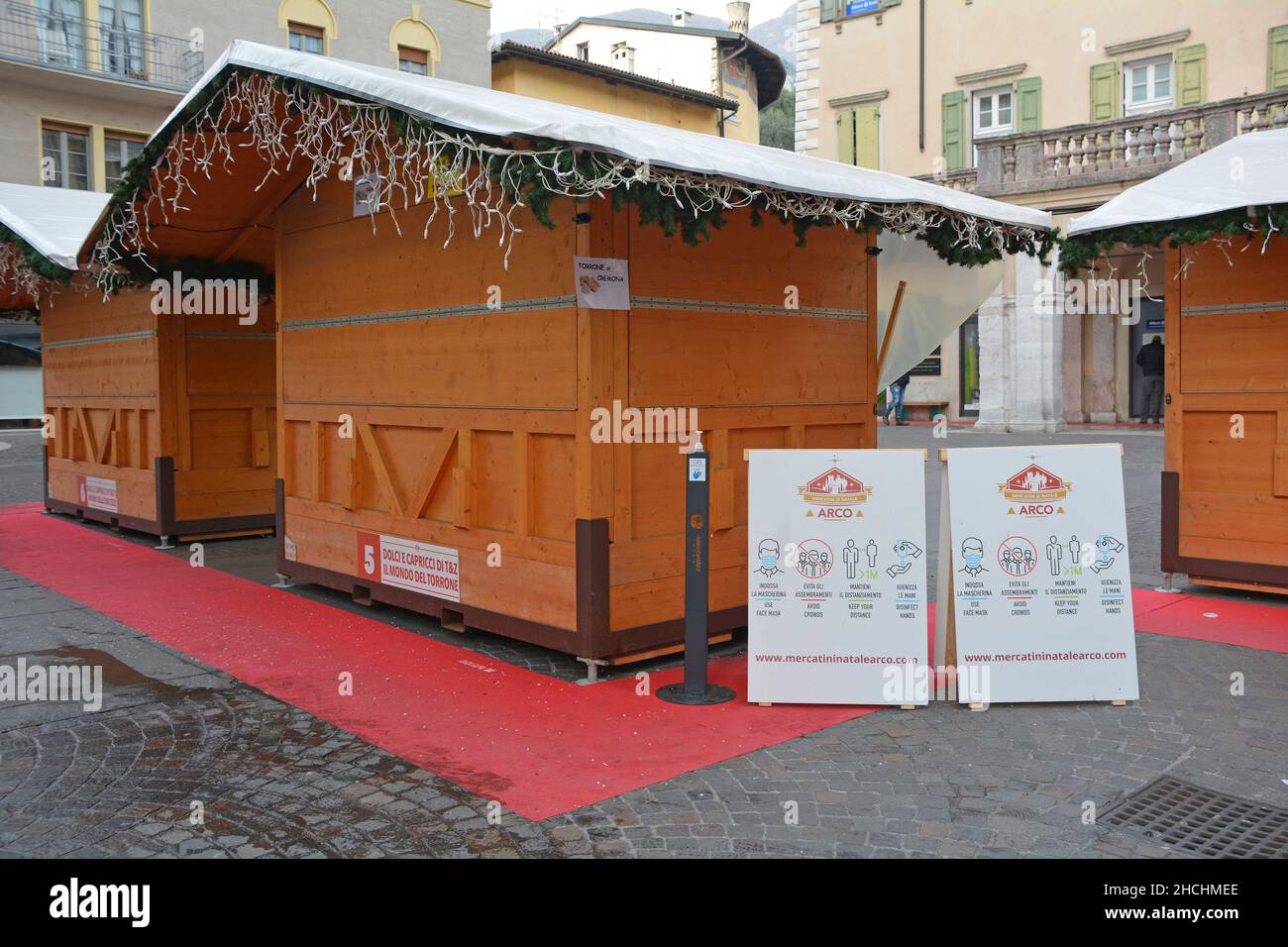 Arco, Italia - Dicembre 25th 2021. Il regolamento Covid-19 si iscrive in un mercatino natalizio all'aperto in Trentino per informare il pubblico delle attuali regole del Covid Foto Stock