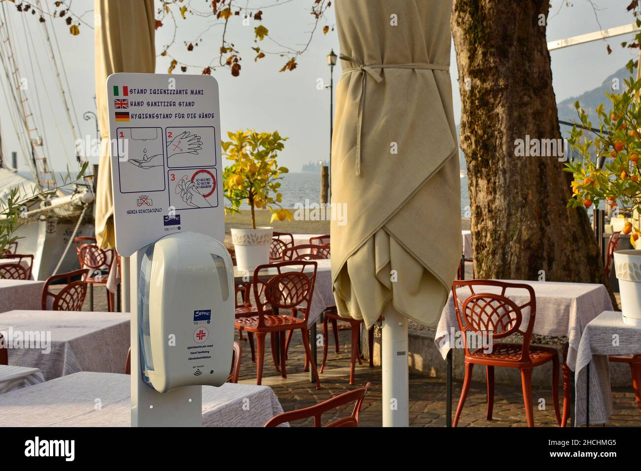 Garda, Italia - Dicembre 27th 2021. Un banco di sanitizzazione manuale all'esterno di un ristorante sulla riva del Lago di Garda in Veneto durante la pandemia del Covid-19 Foto Stock