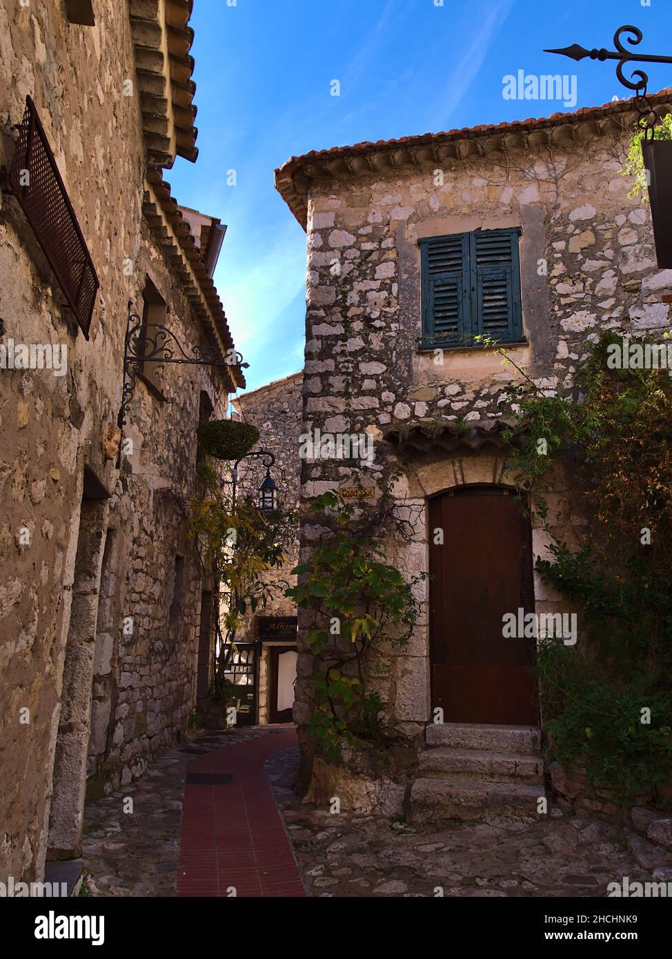 Vicolo stretto nel centro storico della piccola cittadina medievale di Eze Village sulla Costa Azzurra con antichi edifici in pietra nei giorni di sole. Foto Stock