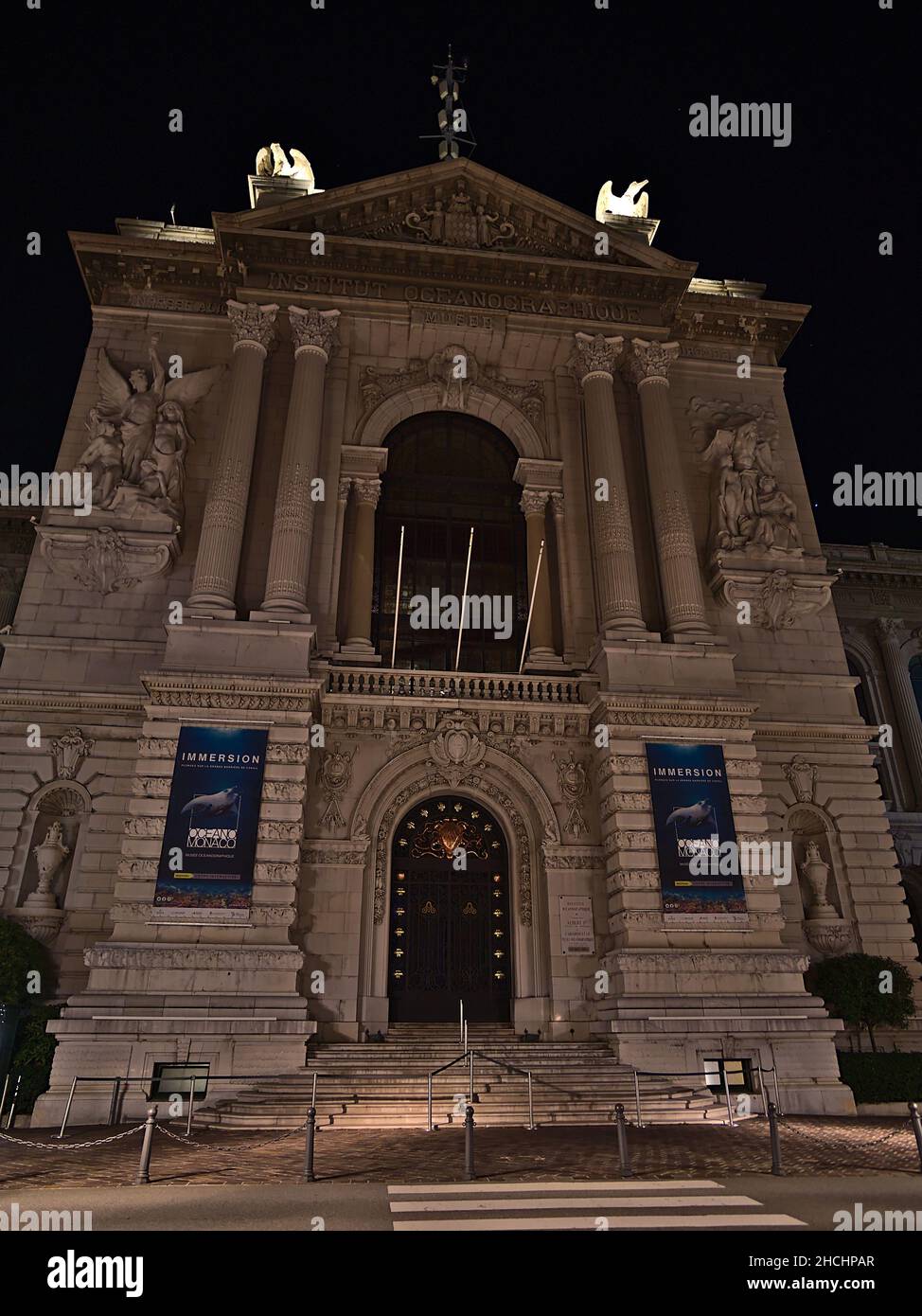 Vista frontale dello storico Museo Oceanografico con facciata decorata illuminata nel Principato di Monaco di notte con facciata illuminata. Foto Stock